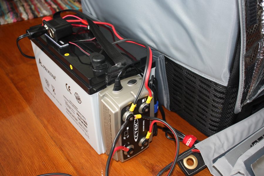 A 12-volt battery connected to a smart charger and maintainer