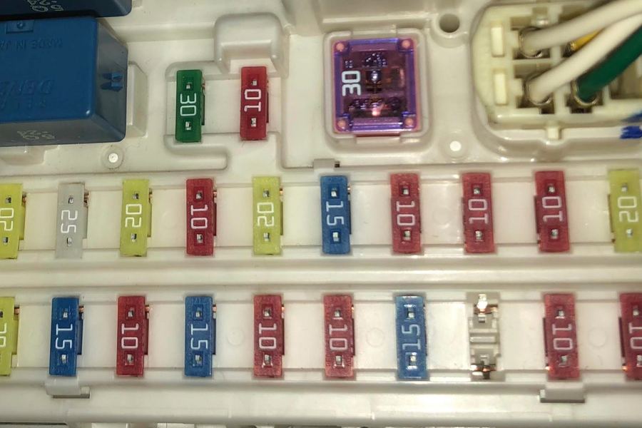 ATO blade fuses seated in a fuse block, with a blue relay at one corner
